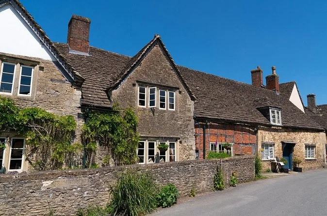 Alte Steinhäuser hinter einer Steinmauer in Lacock