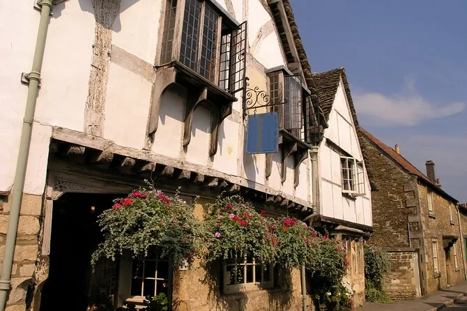 A timber-framed house with hanging flower baskets on a village corner